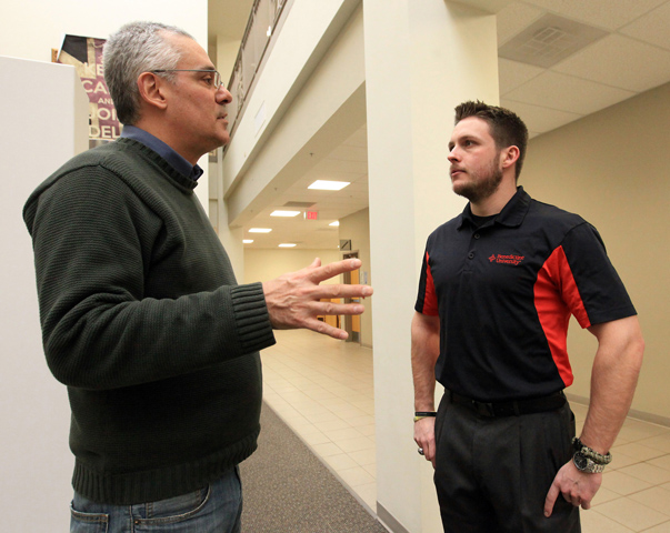 Ian Markert, 26, right, a student at Benedictine University in Lisle, Ill., who is majoring in international business and economics, talks to professor Steven Day in the student hall Jan. 19 about an upcoming trip to China. (CNS/Catholic New World/Karen Callaway)