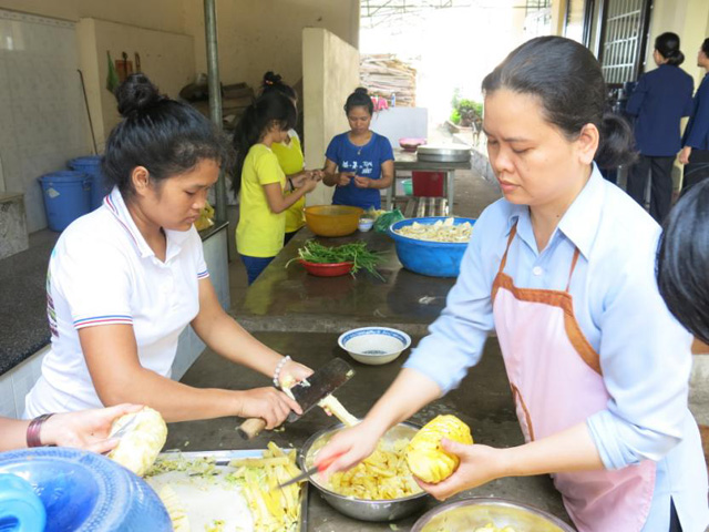 Young women learn how to prepare foods from a nun, right, at the canteen's kitchen. (Joachim Pham) 