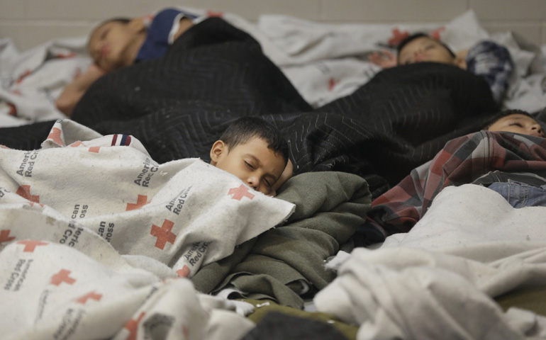 Detainees sleep in a holding cell at a U.S. Customs and Border Protection processing facility in Brownsville, Texas, June 18. (CNS/Reuters/Eric Gay)