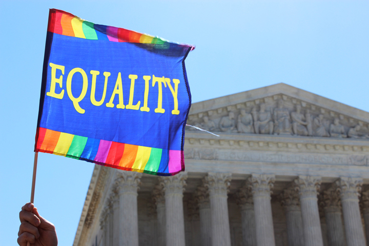 An "equality" flag waves against the sky as crowds gathered in front of the Supreme Court on April 28, 2015, as justices heard arguments about same-sex marriage. (RNS/Adelle M. Banks)