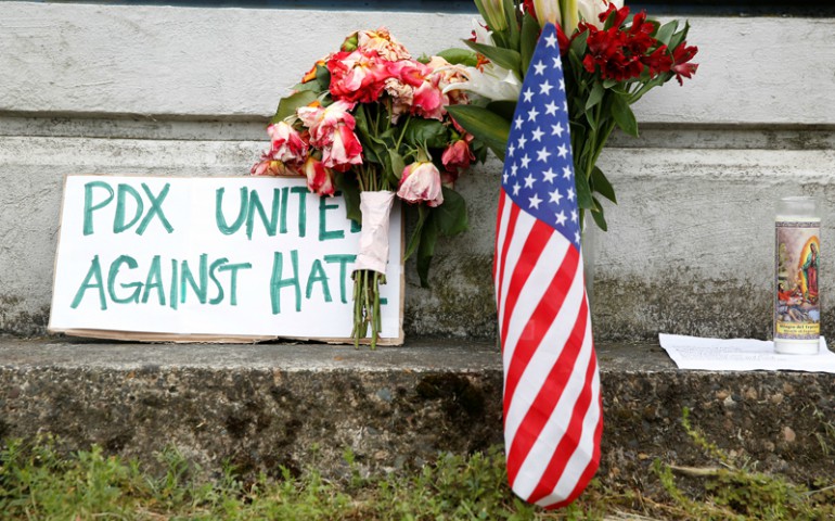 A sign rests against a wall at a makeshift memorial for two men who were killed on a commuter train while trying to stop another man from harassing two young women who appeared to be Muslim, in Portland, Oregon, May 29, 2017. (REUTERS/Terray Sylvester)