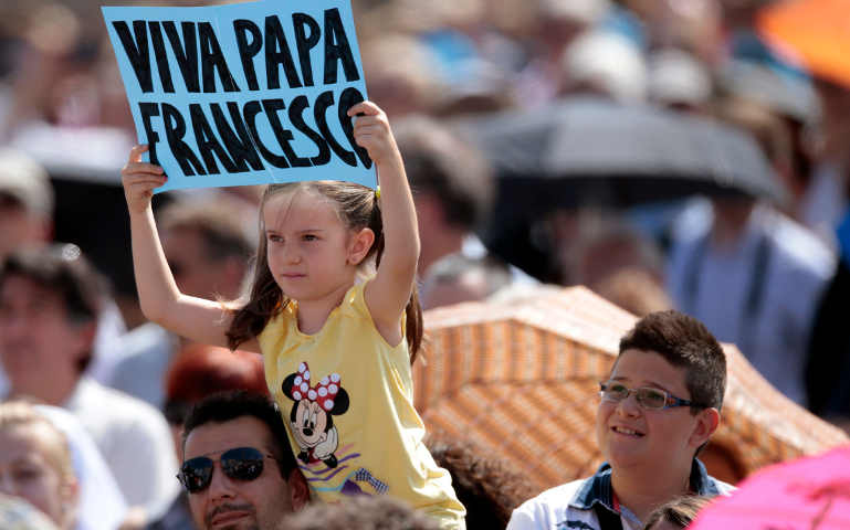A girl holds a banner as Pope Francis leads the Angelus in St. Peter's Square at the Vatican Sept. 1. (CNS/Tony Gentile, Reuters) 