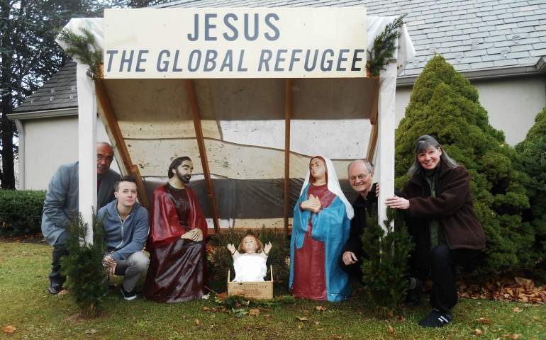 Parishioners pose with the creche at Our Lady of the Miraculous Medal Church. From left to right are Richard Koubek, Anita Halasz, Fr. Bill Brisotti and Alexis Stafford. (NCR photo / Peter Feuerherd)