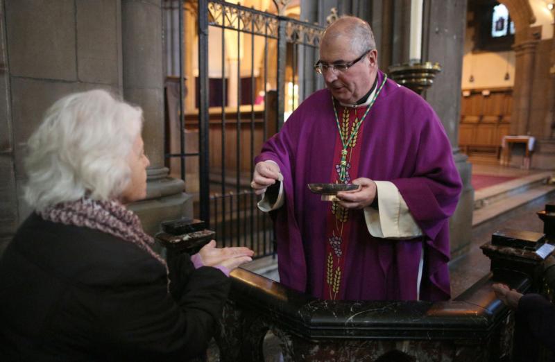 Archbishop Philip Tartaglia of Glasgow, Scotland, serves Communion during Mass in 2013. (CNS photo/David Moir, Reuters)