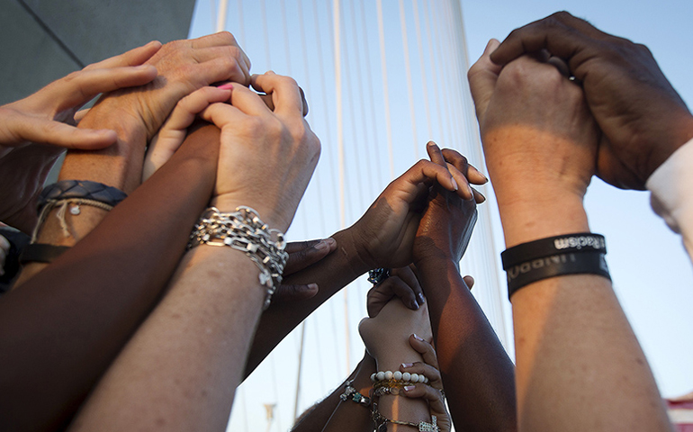 People of different races hold hands as they gather on the Arthur Ravenel Jr. Bridge in Charleston, S.C., on June 21, 2015, after the first service at the Emanuel African Methodist Episcopal Church since a mass shooting left nine people dead. (Reuters/Carlo Allegri)