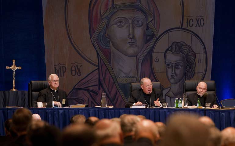 U.S. bishops gather for their annual fall meeting in Baltimore Nov. 12. On the dais from left are Archbishop Joseph E. Kurtz of Louisville, Ky., vice president of the U.S. Conference of Catholic Bishops; New York Cardinal Timothy M. Dolan, president of t he conference; and Msgr. Msgr. Ronny E. Jenkins, general secretary of the conference. (CNS/Nancy Phelan Wiechec)
