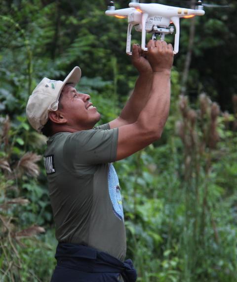 A man catches a drone that was used to locate coca fields in his community's territory in the Peruvian Amazon. (Barbara Fraser)