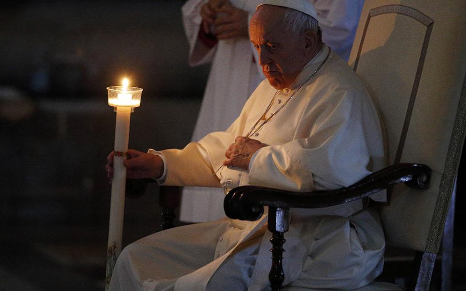Pope Francis holds a candle as he attends the Easter Vigil celebrated by Cardinal Giovanni Battista Re in St. Peter's Basilica at the Vatican April 16. (CNS/Paul Haring)