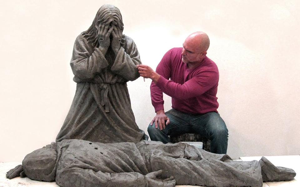 Canadian-based artist Timothy P. Schmalz is pictured in an undated photo working on his life-sized clay sculpture titled "Thou Shalt Not Kill," which depicts Jesus kneeling over a victim of gun violence. Some 60 people gathered March 25 outside of St. Sabina Catholic Church in Chicago for a first look at the sculpture, which the artist donated to the parish. (OSV News/Timothy P. Schmalz)