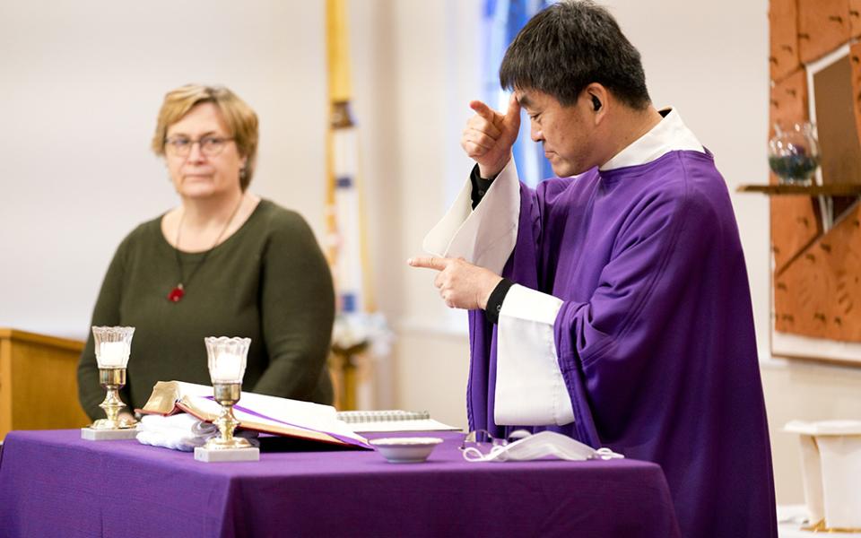Fr. Min Seo Park signs the Mass in American Sign Language on Ash Wednesday, Feb. 17, 2021. To his left is Laureen Lynch-Ryan, the Washington Archdiocese's coordinator for deaf ministry. (Joe Portolano)