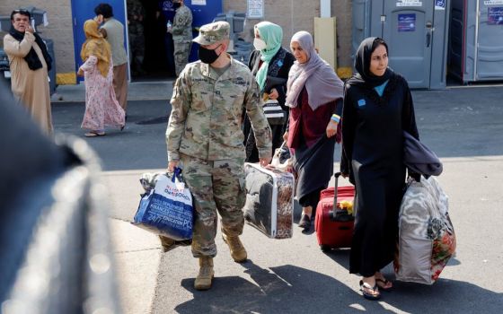 U.S. Army soldiers at the Dulles Expo Center in Chantilly, Va., assist Afghanistan families as they depart an evacuees' processing center Aug. 25. (CNS/Reuters/Jonathan Ernst)