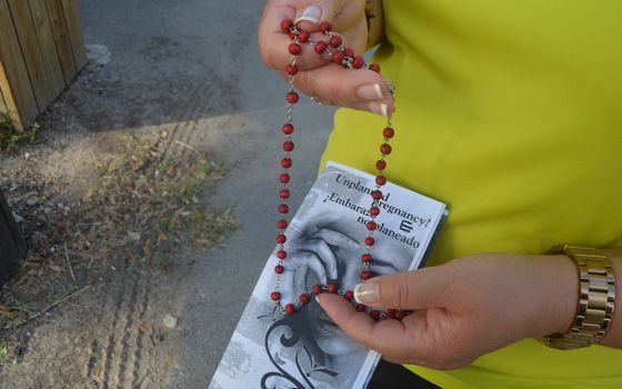 A counselor at the McAllen Pregnancy Center, a Catholic pro-life facility, holds a rosary and literature about abortion during a 2015 walk outside a clinic that provides abortions in McAllen, Texas. (CNS/The Valley Catholic/Rose Ybarra)
