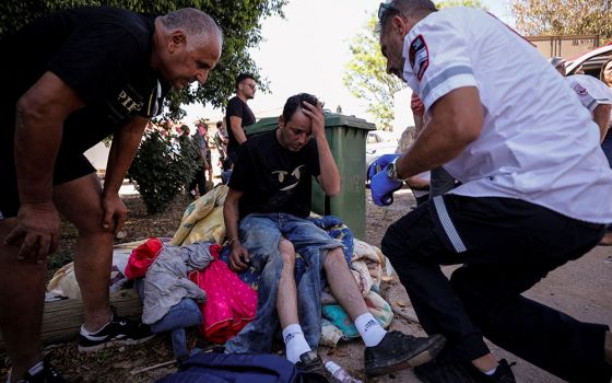 An Israeli medic treats a man who was wounded after a rocket launched from the Gaza Strip landed near homes in Moshav Zohar, Israel, May 13. (CNS/Reuters/Amir Cohen)