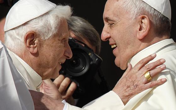 Retired Pope Benedict XVI greets Pope Francis during an event for the elderly in St. Peter's Square at the Vatican Sept. 28, 2014. Pope Benedict planned to live a "hidden life" in retirement, but to the delight and surprise of pilgrims and cardinals, he appeared at events with Pope Francis several times. (CNS photo/Paul Haring)