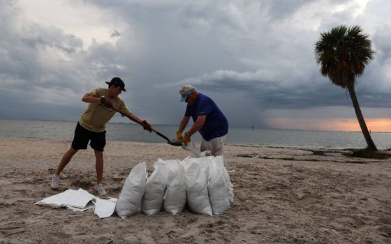 Rich Reynolds and his son, John, fill sandbags in Tampa, Fla., Sept. 26, 2022, as Hurricane Ian spun toward the state. (CNS photo/Shannon Stapleton, Reuters)
