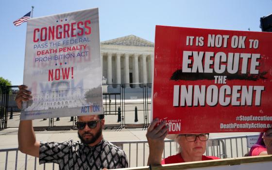 Demonstrators hold signs protesting capital punishment in front of the U.S. Supreme Court building in Washington June 29, 2022. Catholics should mark Christ's suffering and death on Good Friday with prayers for an end to the use of the death penalty, Catholic opponents of the practice said. (OSV News photo/Kevin Lamarque, Reuters)
