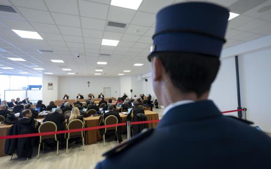 A Vatican police officer keeps watch March 16, 2023, during the trial of Cardinal Angelo Becciu and nine other defendants on charges of financial malfeasance. The trial is being held in a makeshift courtroom at the Vatican Museums. (CNS photo/Vatican Media)