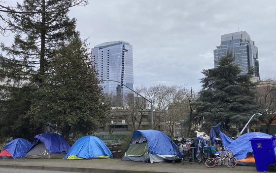 People camp in tents next to the Interstate 405 freeway, March 31 in Portland, Oregon. (AP photo/Eric Risberg)