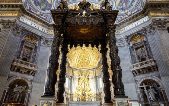 The baldachin, an ornate, dark-colored four-posted covering, is seen above the altar at St. Peter's Basilica