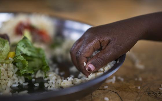 A girl eats at a school Sept. 19, 2022, in Dollow, Somalia. The Famine Early Warning Systems Network predicts that by July, parts of Somalia and eight other countries will be at internationally recognized emergency levels of food insecurity. (AP photo/Jerome Delay, File)