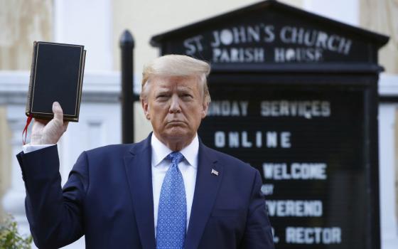 Donald Trump holds bible inf front of church sign.