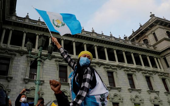 A woman holds up a Guatemalan flag during a protest to demand the resignation of President Alejandro Giammattei in Guatemala City Nov. 22. (CNS/Reuters/Luis Echeverria)