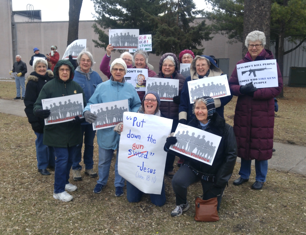 Franciscan Sisters of Perpetual Adoration gather at the downtown March for Our Lives in La Crosse, Wisconsin, while another group of the sisters march in solidarity with the students at St. Rose Convent, the congregational motherhouse across town.