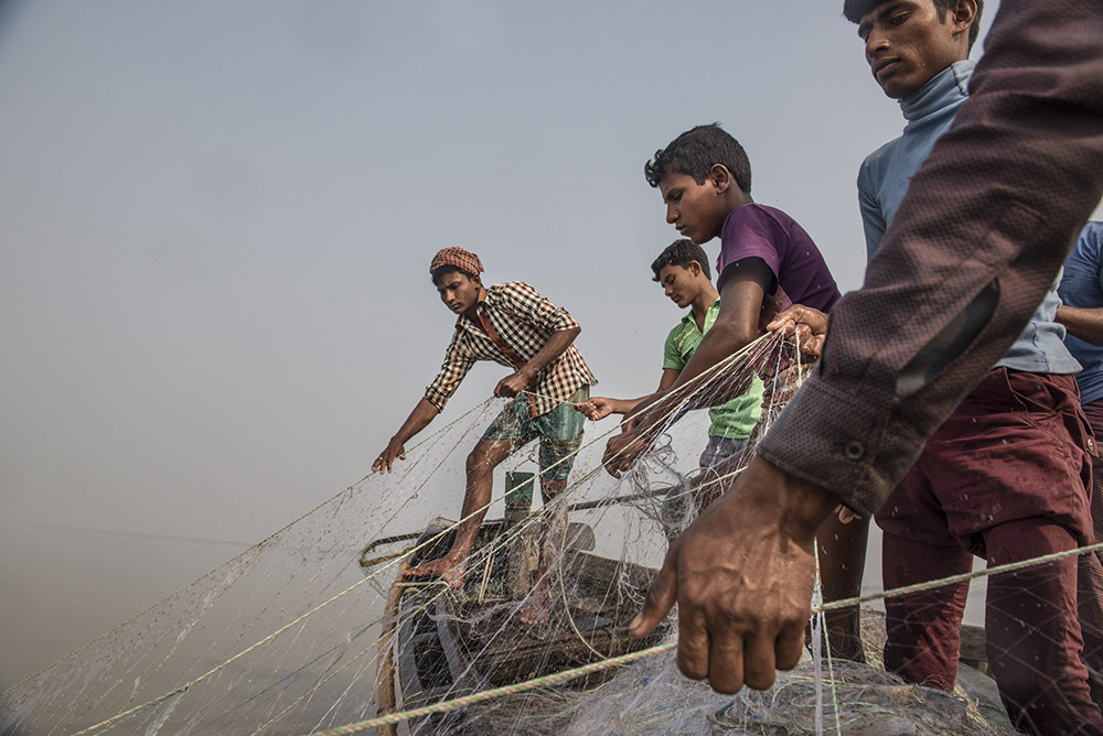 Fishermen cast their nets into the junction between the Meghna River and the Bay of Bengal off Monpura Island in Bangladesh.