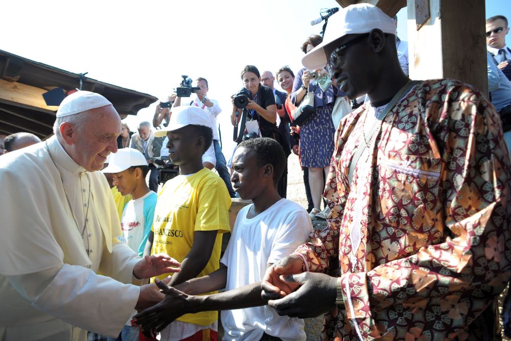 Pope Francis greets immigrants at the port in Lampedusa, Italy, July 8, 2013. There he remembered African and Middle Eastern migrants who died when their boats capsized as they were trying to reach Europe. 
