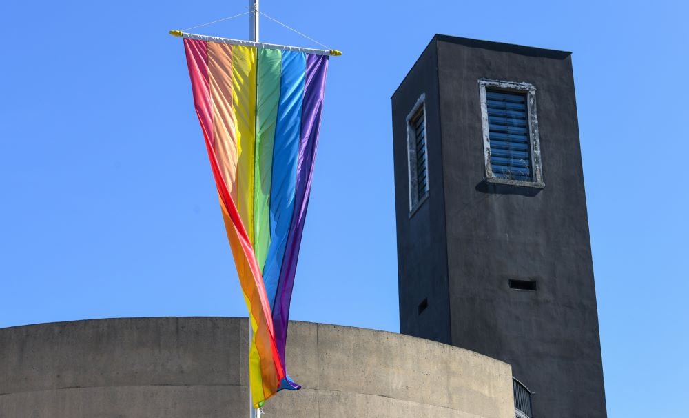A gay pride flag hangs outside the Church of St. Theodore in Cologne, Germany, in March. Archbishop Heiner Koch of Berlin said he would appoint a pastoral minister for gays, the archdiocese announced in August. (CNS photo/KNA/Harald Oppitz)