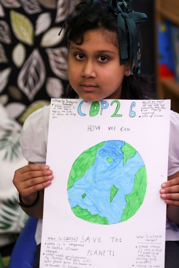 A student holds a poster at St. Conval's Primary School while learning about climate change ahead the U.N. Climate Change Conference, COP26. (CNS/Reuters/Russell Cheyne)