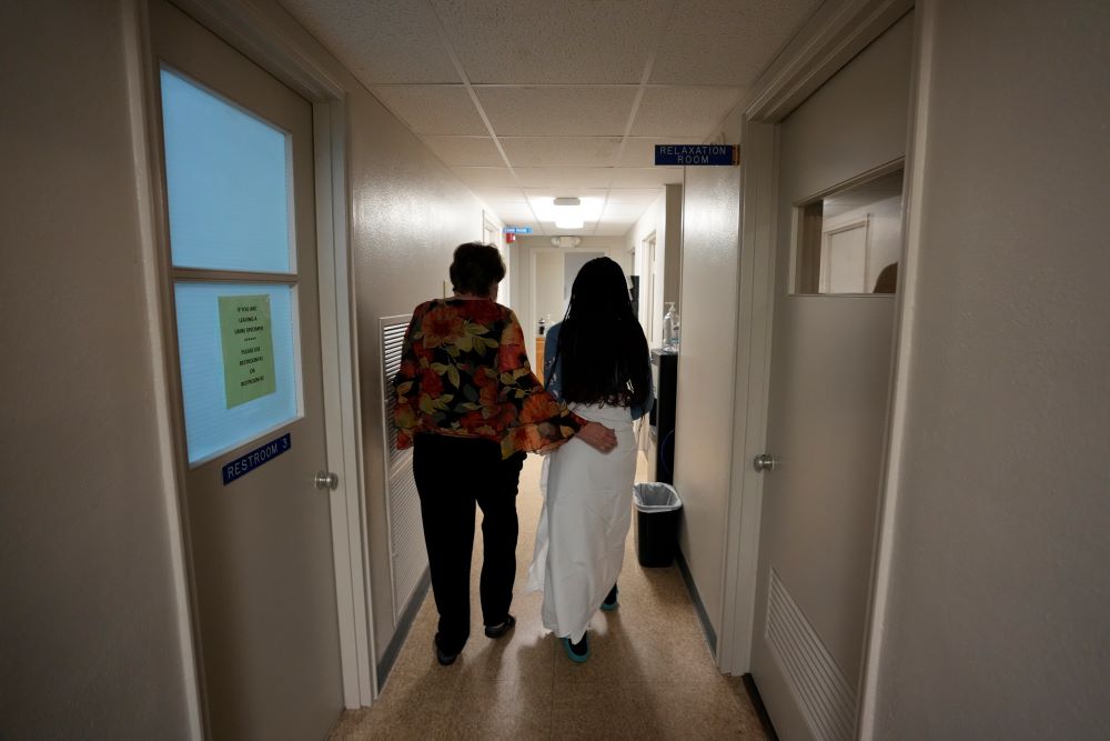 A 33-year-old mother of three from central Texas is escorted down the hall by clinic administrator Kathaleen Pittman before getting an abortion Oct. 9 at Hope Medical Group for Women in Shreveport, La. (AP/Rebecca Blackwell)