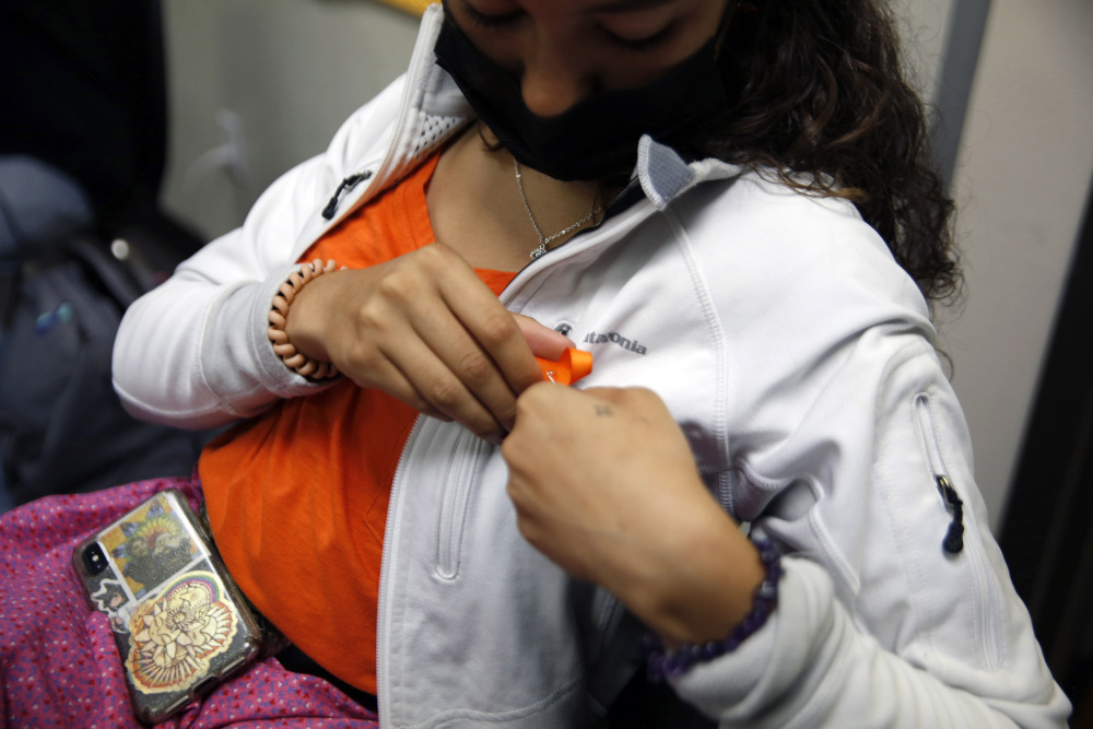 Esperanza Rama, a sophomore at Red Cloud Indian School, pins an orange ribbon to her shirt on Sept. 20, 2021, in Pine Ridge, S.D. (AP/Emily Leshner)