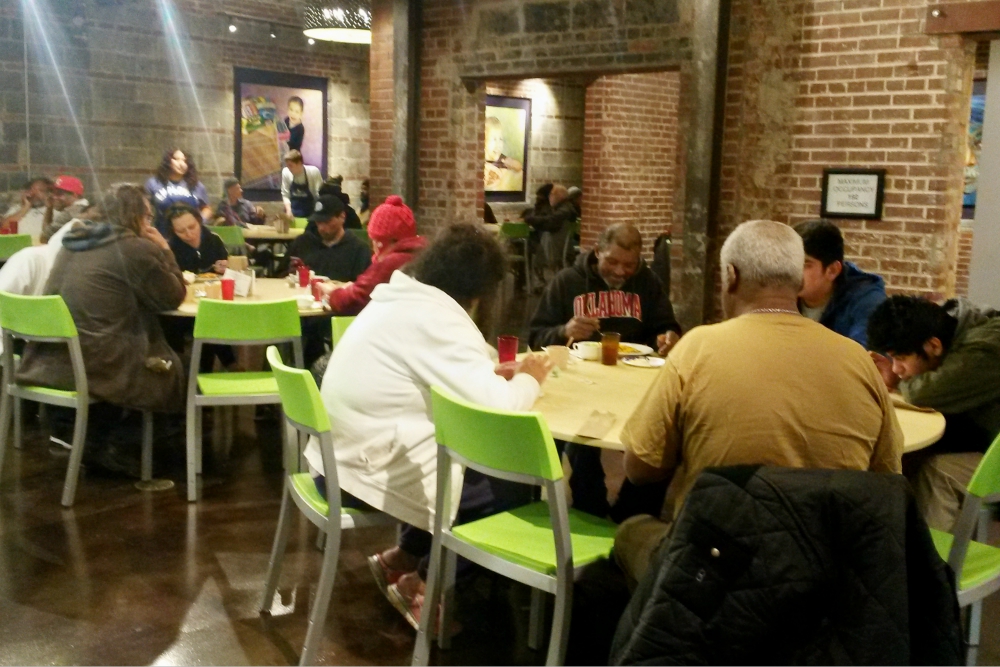 People enjoy dinner at Bishop Sullivan Center's One City Café, a restaurant-style community kitchen offering free meals in Kansas City, Missouri, as volunteers and staff serve them Feb. 26. (NCR photo/Maria Benevento) People enjoy dinner at Bishop Sullivan Center's One City Café, a restaurant-style community kitchen offering free meals in Kansas City, Missouri, as volunteers and staff serve them Feb. 26. (NCR photo/Maria Benevento)