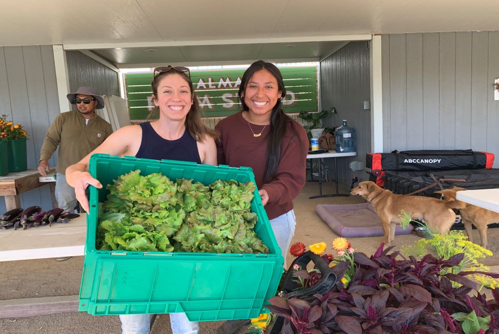 Erika L. Cuellar, operations director and co-founder and Isabella Andreoni, executive assistant, show off produce at ALMA Backyard Farms Compton, California, Feb. 3. The project was founded in 2013. (Melissa Cedillo)  