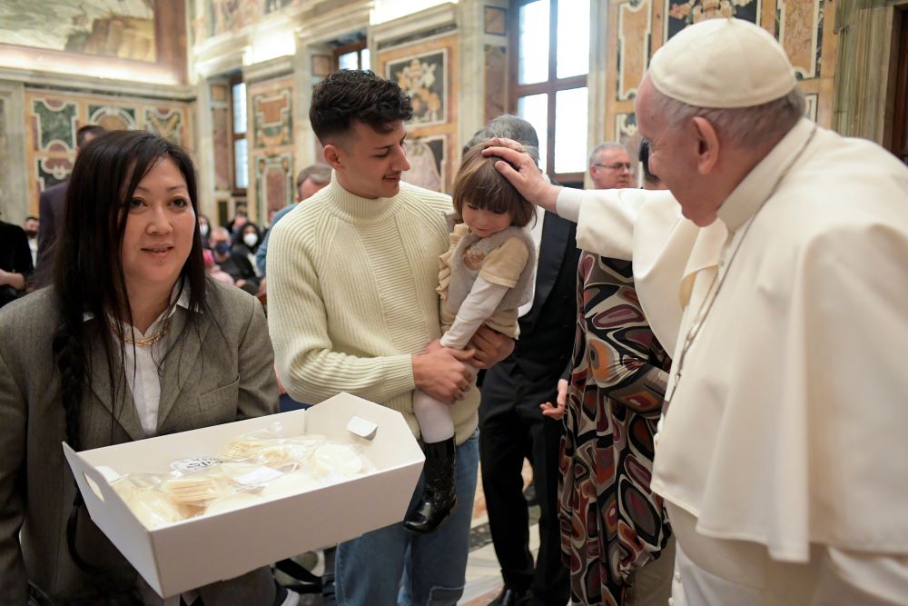 Pope Francis accepts Communion hosts as he greets people during an audience with members of the Casa dello Spirito e delle Arti Foundation at the Vatican Feb. 4. (CNS/Vatican Media)