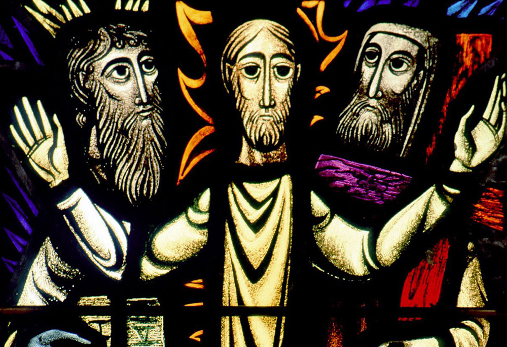 A church window depicts the Transfiguration of Christ, in which Moses and Elijah are seen with Jesus in a glorified state before the apostles Peter, James and John. (CNS/Crosiers) A church window depicts the Transfiguration of Christ, in which Moses and Elijah are seen with Jesus in a glorified state before the apostles Peter, James and John. (CNS/Crosiers)