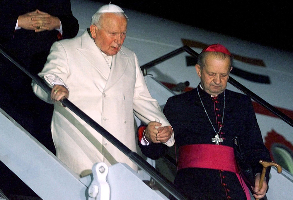 Pope John Paul II is aided down the stairs of an airplane by his personal secretary, then-Bishop Stanislaw Dziwisz, after arriving in Rome after a trip to India and Georgia in this Nov. 9, 1999, file photo. (CNS/Reuters/Paolo Cocco)