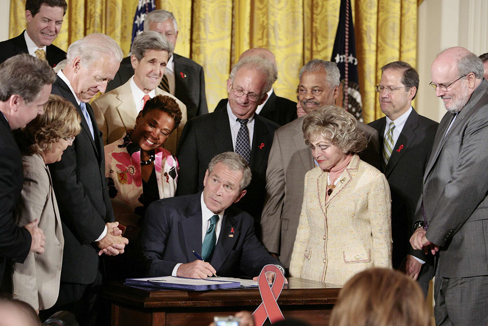 President George W. Bush signs a bill that extends the President’s Emergency Program for AIDS Relief, known as PEPFAR, surrounded by lawmakers and other supporters of the program at the White House in Washington July 30, 2008. (CNS/Reuters/Larry Downing)