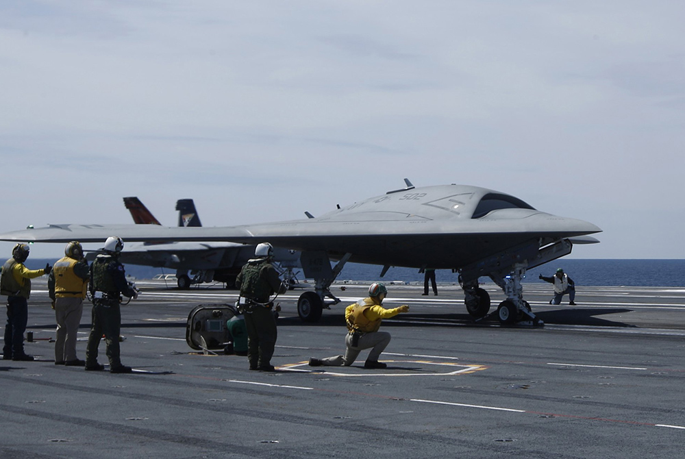 Crew members prepare May 14, 2013, to launch an X-47B pilot-less drone combat aircraft for the first time off an aircraft carrier Crew members prepare May 14, 2013, to launch an X-47B pilot-less drone combat aircraft for the first time off an aircraft carrier, the USS George H. W. Bush in the Atlantic Ocean off the coast of Virginia. (CNS/Reuters/Jason Reed)