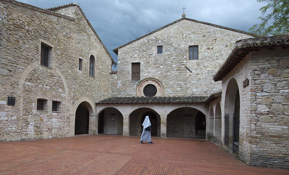 A nun walks the courtyard at the church and convent of San Damiano in Assisi, Italy. (CNS/Octavio Duran)
