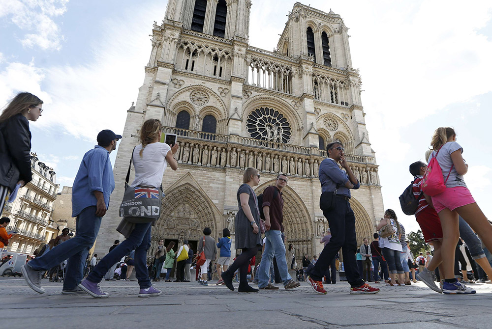 People stand in line outside Notre Dame Cathedral Aug. 22, 2014, in Paris. (CNS/Reuters/Charles Platiau)