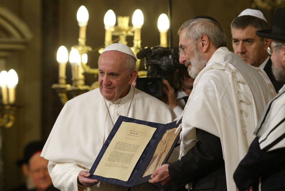 In a 2016 file photo, Pope Francis and Rabbi Riccardo Di Segni, the chief rabbi of Rome, hold a codex containing five pages of Jewish biblical commentary at the main synagogue in Rome. (CNS/Paul Haring)