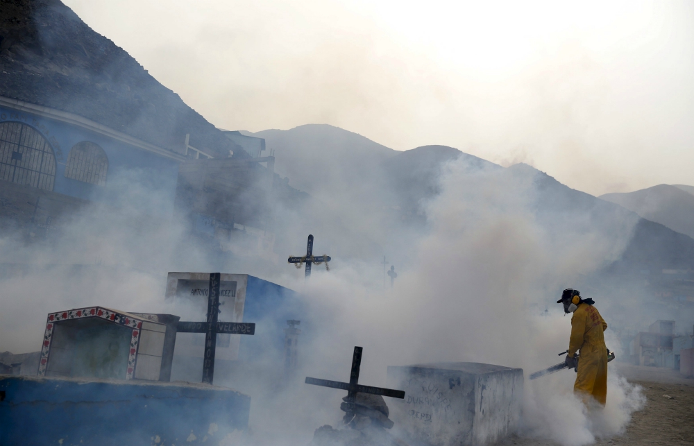 A health worker fumigates for mosquitoes as part of preventive measures against the Zika virus at a cemetery Feb. 1, 2016, near Lima, Peru. (CNS/Reuters/Mariana Bazo)