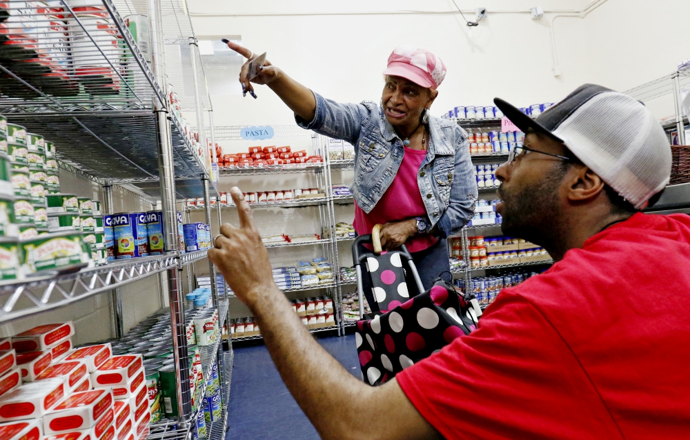 Volunteer Mark Orr assists a woman in July 2016 at a new food pantry at Catholic Charities of the Archdiocese of New York's community center in the South Bronx. (CNS/Gregory A. Shemitz)