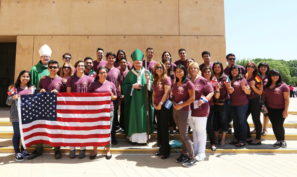 Los Angeles Archbishop José Gomez, center, and Auxiliary Bishop Robert Barron pose for a photo at the Cathedral of Our Lady of the Angels with a group of World Youth Day pilgrims who received a send-off blessing July 17, 2016. (CNS/Victor Aleman)