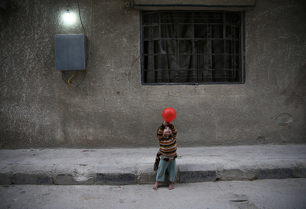 A child plays with a balloon Nov. 13, 2016, in Douma, Syria. In previous years, sanctions by the United States denied industrial parts to Syria and crippled its airline industry. (CNS/Reuters/Bassam Khabieh) A child plays with a balloon Nov. 13, 2016, in Douma, Syria. In previous years, sanctions by the United States denied industrial parts to Syria and crippled its airline industry. (CNS/Reuters/Bassam Khabieh)