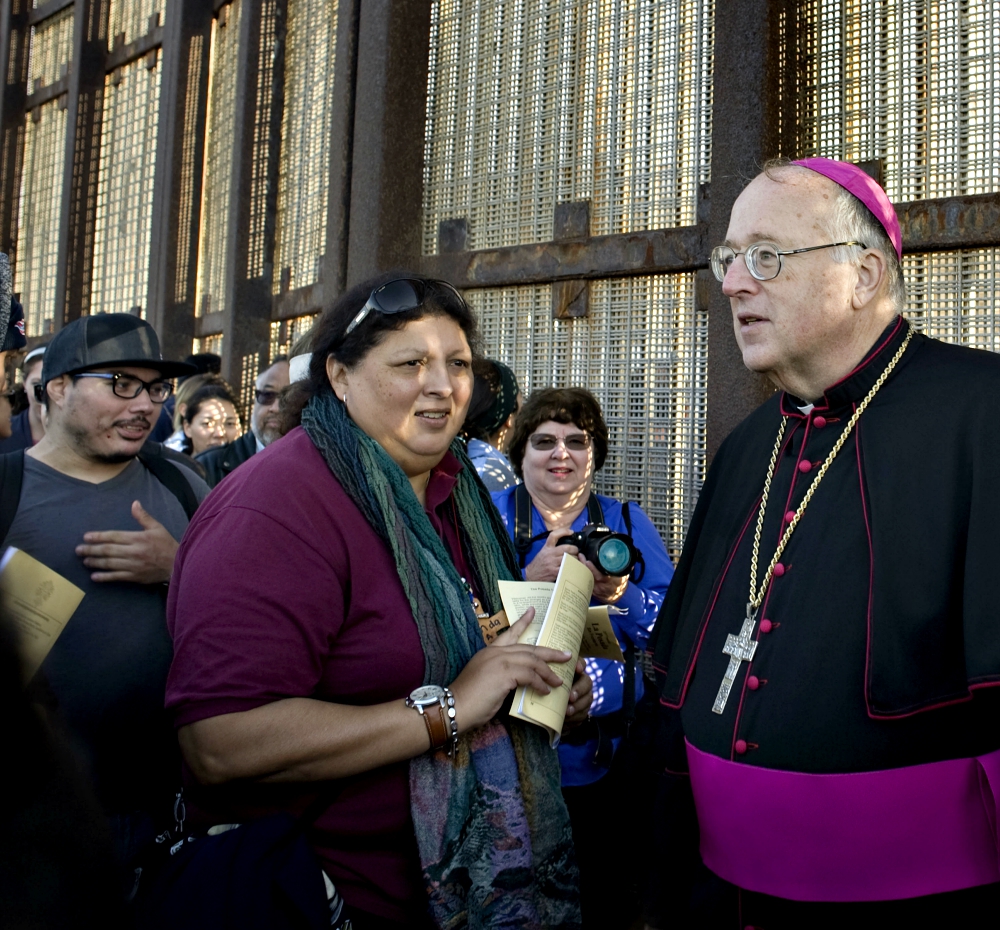 San Diego Bishop Robert McElroy speaks with people at the U.S.-Mexico border fence in San Diego Dec. 10, 2016. (CNS/David Maung)