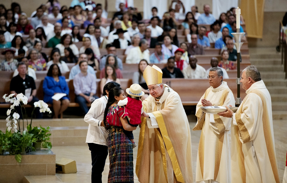 Archbishop José Gomez blesses a Mayan family from Guatemala during the presentation of the gifts at a June 18 Mass celebrated in recognition of all immigrants at the Cathedral of Our Lady of the Angels in Los Angeles.
