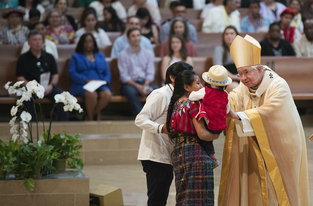 Archbishop José Gomez blesses a Mayan family from Guatemala during the presentation of the gifts at a June 18, 2017, Mass celebrated in recognition of all immigrants at the Cathedral of Our Lady of the Angels in Los Angeles. (CNS/Angelus News)